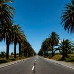 "Persona caminando bajo la lluvia en Montevideo durante un día nublado según el pronóstico de Inumet"