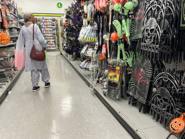 Personas comprando decoraciones y dulces para Halloween, reflejo del impacto económico y comercial de la festividad en todo el mundo.