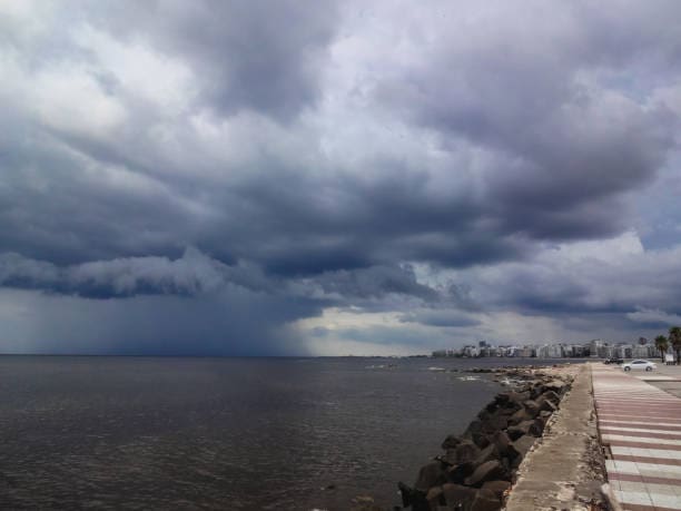 "Persona camina bajo la lluvia en Montevideo durante un día nublado según el pronóstico del tiempo de Inumet"