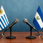 Mesa de diálogo con banderas de Uruguay y El Salvador, simbolizando el debate entre Orsi y Bukele sobre seguridad.