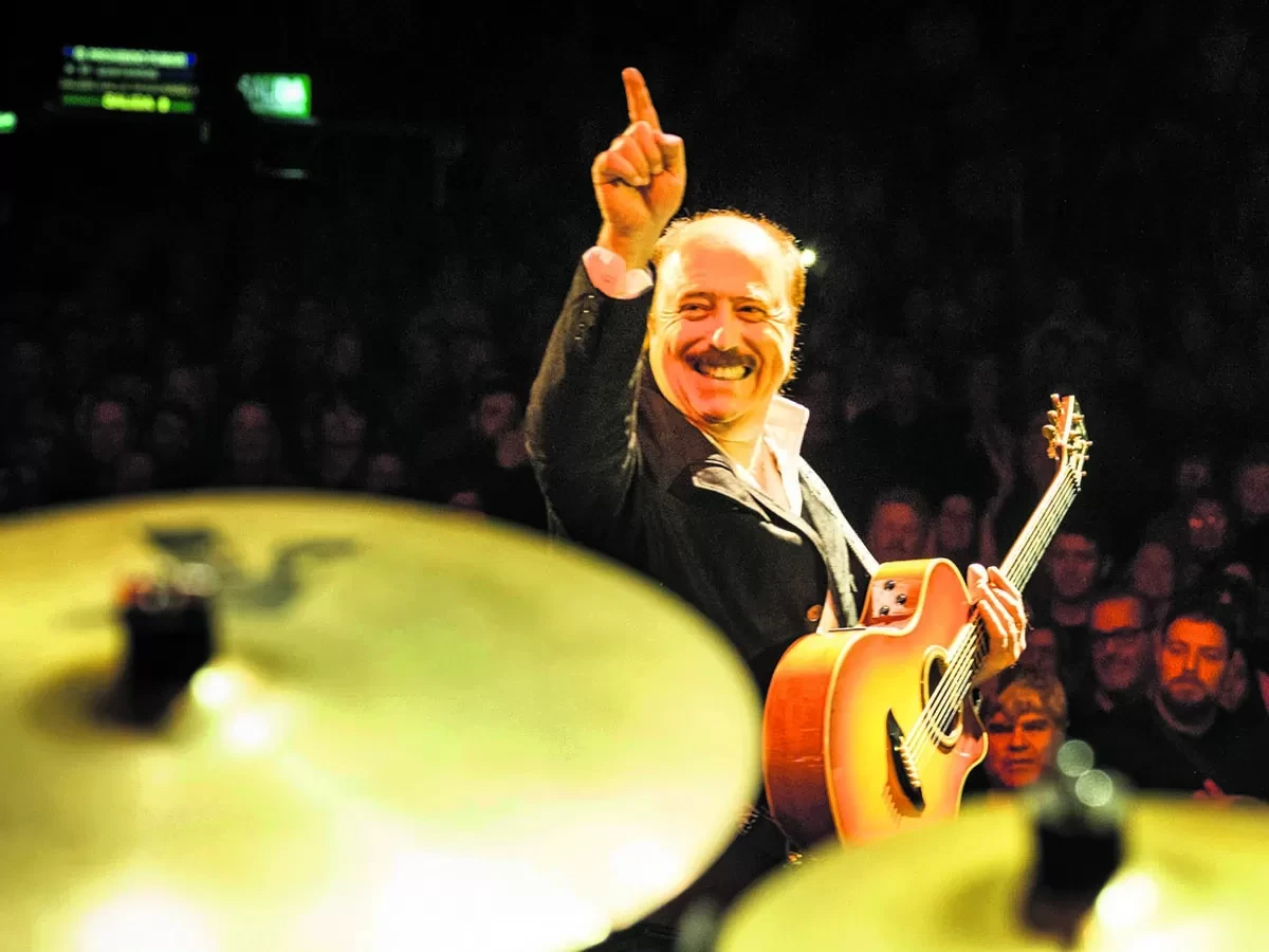 Jaime Roos caminando por la rambla con mirada reflexiva en día nublado