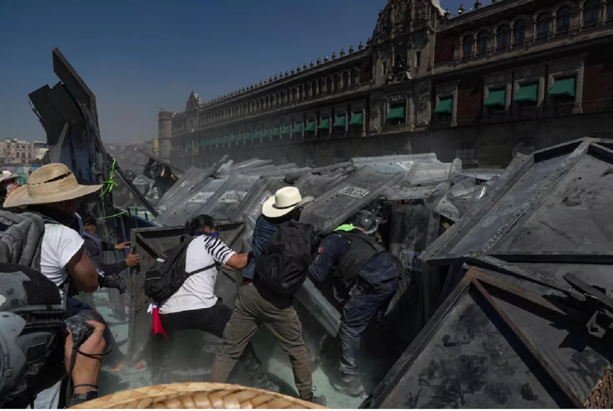 Escena de tensión en el Zócalo durante “México al rojo vivo por protestas”, con policías y manifestantes enfrentados. manifestación masiva en cdmx durante méxico al rojo vivo por protestas