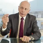 El Dr. Gustavo Salle gesticulando con énfasis durante una entrevista sobre el recorte de legisladores en Uruguay.