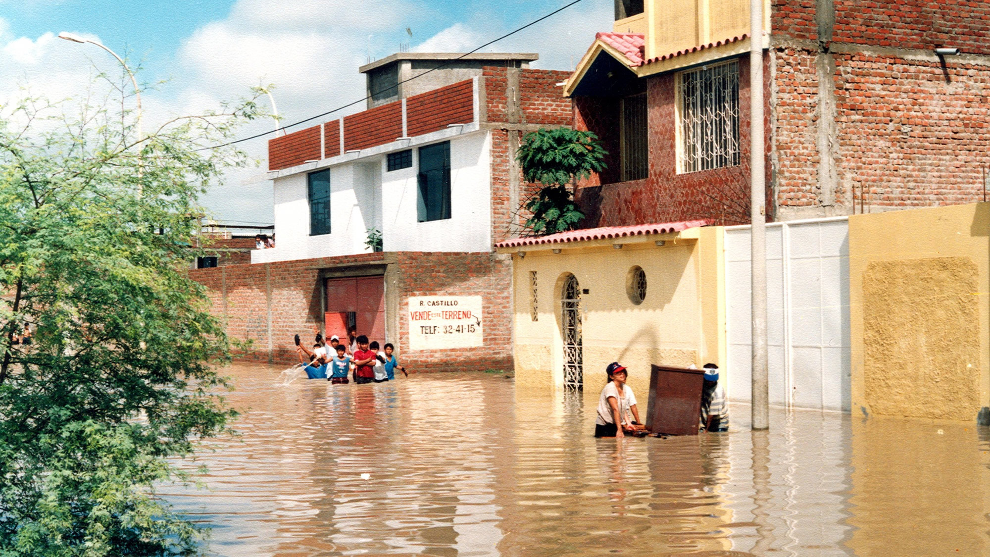 Inundación destructiva arrasando una zona urbana bajo el impacto del fenómeno de El Niño en Perú.