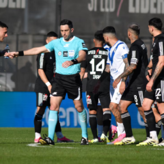 Nazareno Arasa rodeado de futbolistas tras anular el gol de Vélez en el partido contra Riestra.