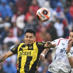 Jugadores de Peñarol y Nacional durante un clásico del fútbol uruguayo disputado en el Estadio Campeón del Siglo.