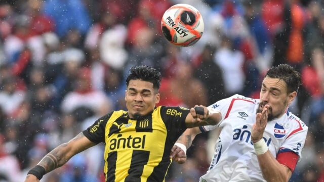 Jugadores de Peñarol y Nacional durante un clásico del fútbol uruguayo disputado en el Estadio Campeón del Siglo.