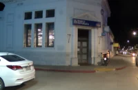 Vista frontal del edificio bancario durante la investigación policial tras el asalto al BROU de Pando.