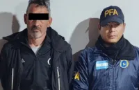 Fotografía de Pablo Bebote Álvarez detenido flanqueado por agentes de la Policía Federal Argentina