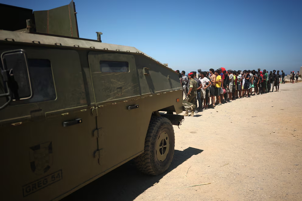 Militares y sanitarios auxilian a personas llegadas por mar durante la crisis migratoria de Ceuta
