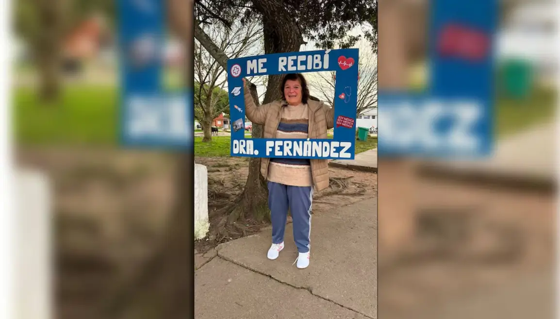 Una mujer uruguaya se recibe de médica a los 65 años y sostiene su cuadro de graduación.