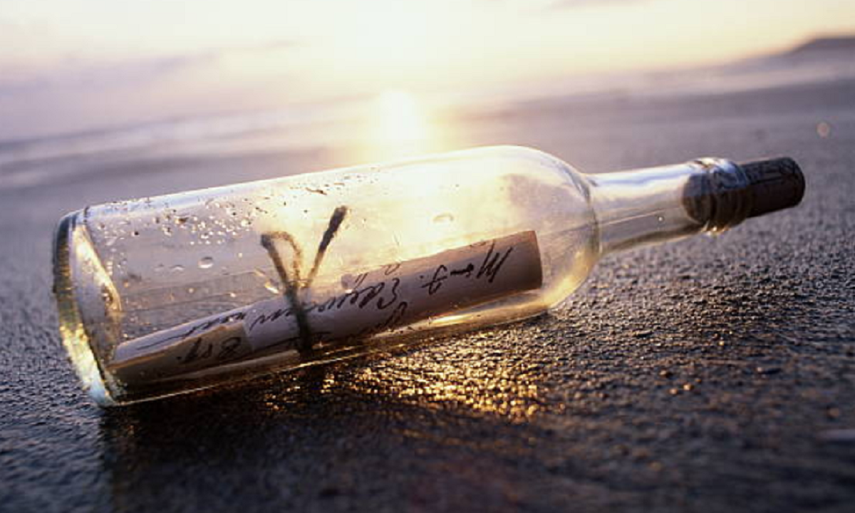 Botella de cristal con mensajes escritos a mano en su interior hallada en la playa.