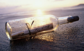 Botella de cristal con mensajes escritos a mano en su interior hallada en la playa.