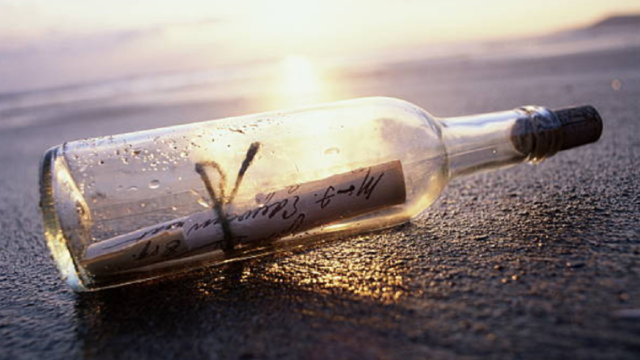 Botella de cristal con mensajes escritos a mano en su interior hallada en la playa.