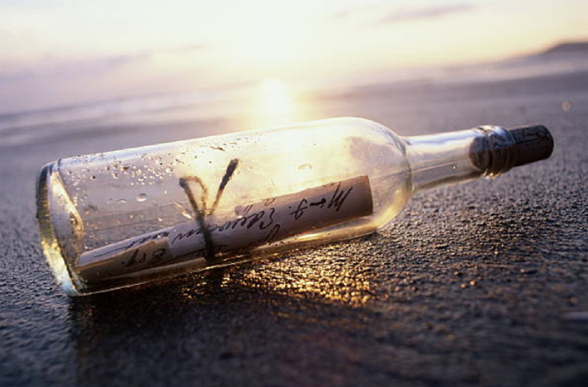 Botella de cristal con mensajes escritos a mano en su interior hallada en la playa.