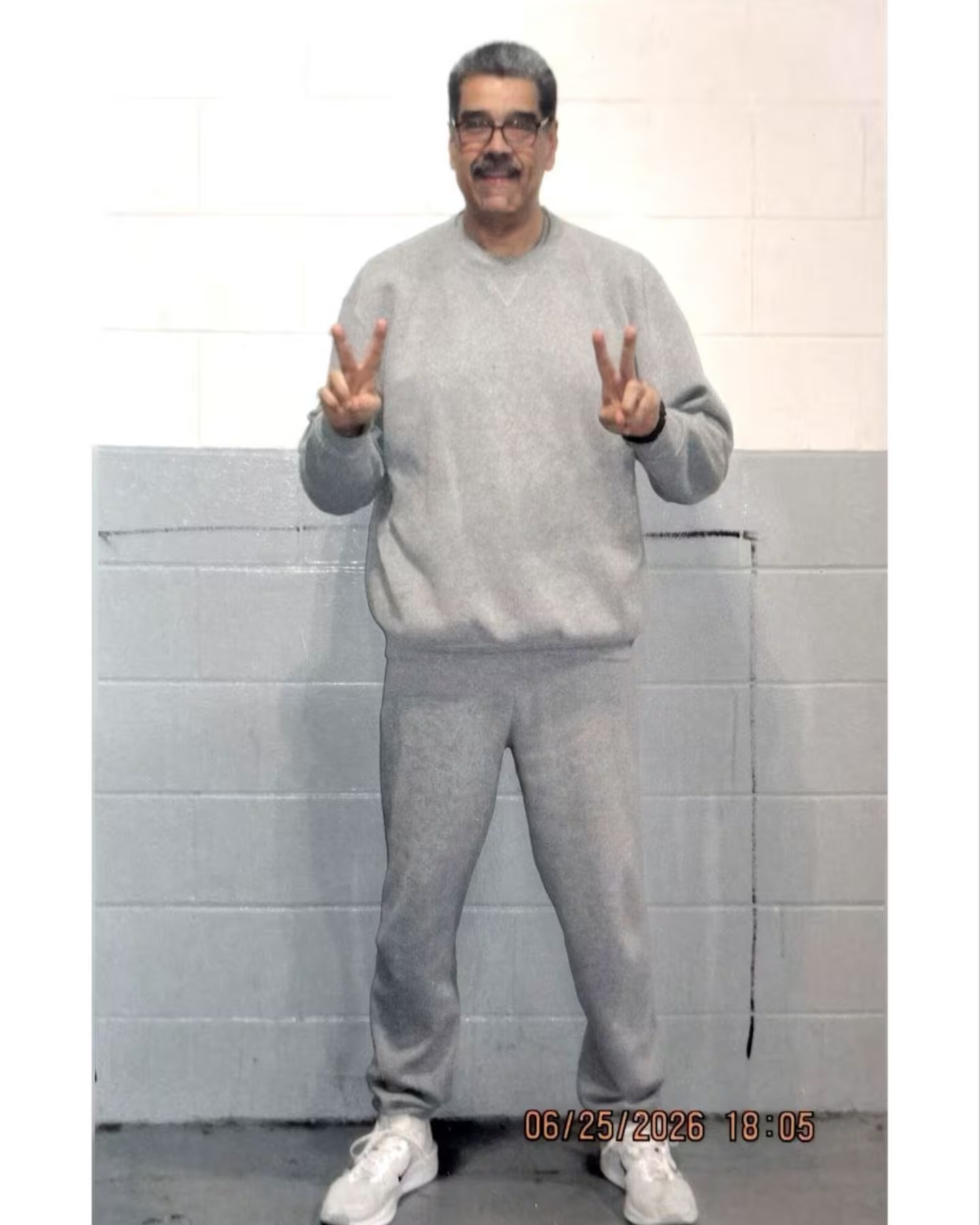Nicolás Maduro sonriendo y haciendo el gesto de la V con los dedos desde el penal en Estados Unidos.