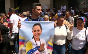 Manifestantes opositores desplegando una bandera venezolana durante una marcha en el centro de Caracas.