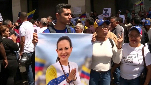 Manifestantes opositores desplegando una bandera venezolana durante una marcha en el centro de Caracas.