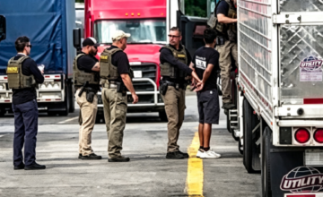 Agentes del ICE realizando la inspección de un camión de carga en una autopista.