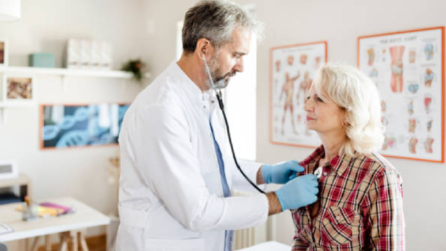 Profesional médico analizando resultados de un ensayo clínico sobre el corazón en una pantalla.