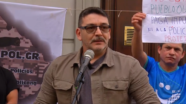 Manifestantes con pancartas y banderas frente a la puerta del Ministerio del Interior.
