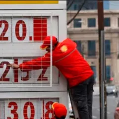 Estación de servicio en Santiago de Chile con mangueras de combustible y cartel de precios.