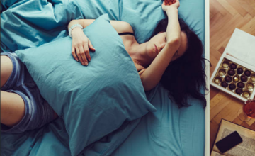 Persona descansando en la cama con gesto de molestia por dolor de cabeza.