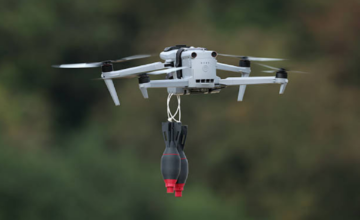 Dron de reconocimiento volando a baja altura sobre una pista de aterrizaje aeroportuaria.
