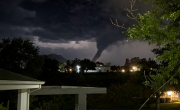 Formación de nube embudo o germen de tornado descendiendo desde un cielo tormentoso.