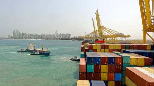 Camión transportando contenedores de carga en zona portuaria.