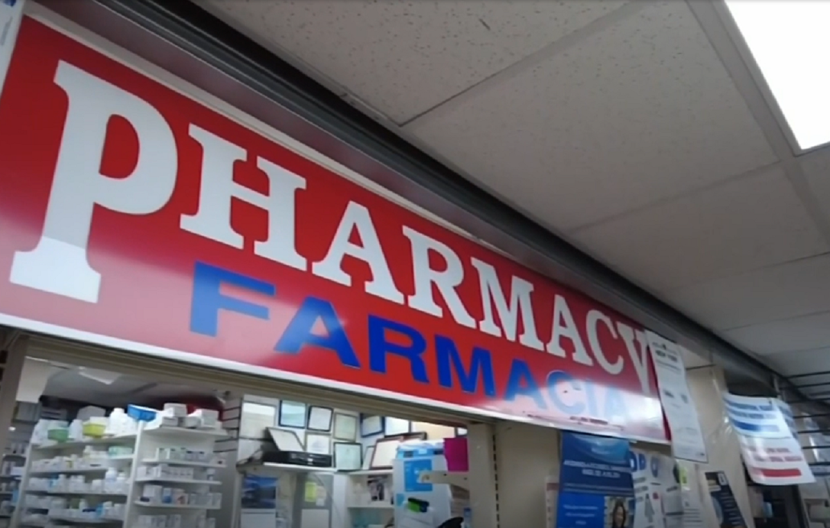 Persona mayor conversando con un farmacéutico en un establecimiento de salud.