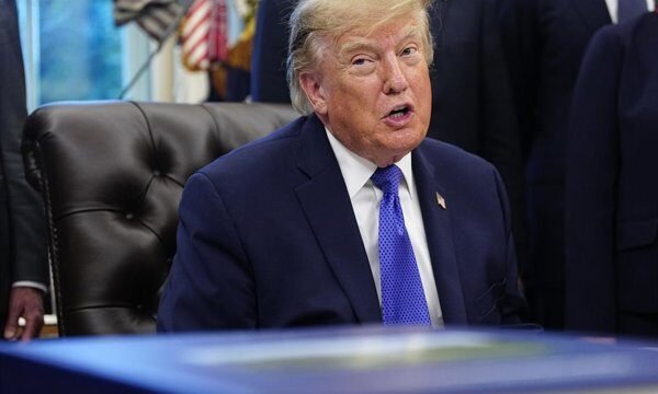 Donald Trump dando un discurso en un estrado durante un acto político.