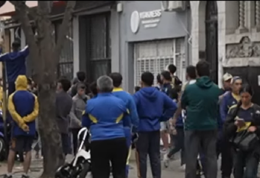 Familia asistiendo a un joven en la vereda tras los incidentes afuera de la cancha.