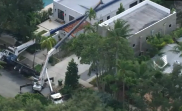 Dos grúas de gran porte caídas sobre el techo dañado de una vivienda en Fort Lauderdale.