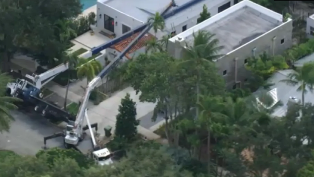 Dos grúas de gran porte caídas sobre el techo dañado de una vivienda en Fort Lauderdale.