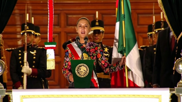 La presidenta Claudia Sheinbaum saludando desde el balcón presidencial durante los festejos patrios.