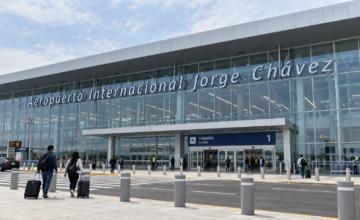 Agente de seguridad inspeccionando un power bank en la bandeja del escáner de un aeropuerto.