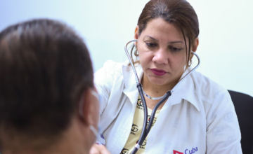Médico oftalmólogo cubano realizando una revisión ocular a un paciente.