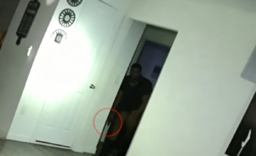 Cámara corporal policial capturando imágenes durante un procedimiento táctico.
