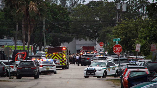 Patrullas policiales y cinta de preservación en una calle residencial de Miami tras un tiroteo.