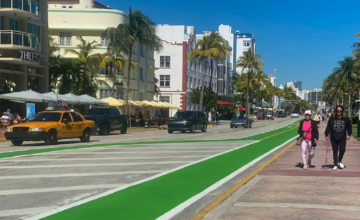 Paseo peatonal en Ocean Drive con personas caminando frente a edificios de arquitectura Art Déco.