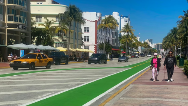Paseo peatonal en Ocean Drive con personas caminando frente a edificios de arquitectura Art Déco.
