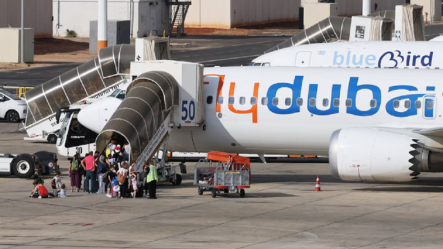 Pasajeros descendiendo por la rampa de una aeronave comercial tras un aterrizaje forzoso.