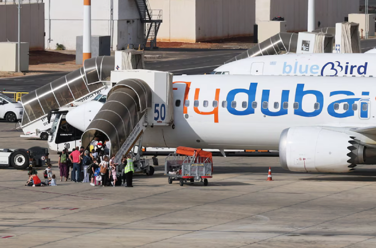 Pasajeros descendiendo por la rampa de una aeronave comercial tras un aterrizaje forzoso.