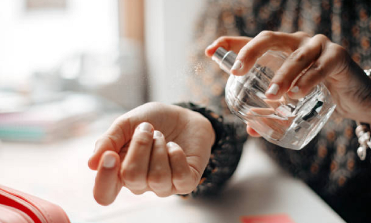 Envases de perfumes y cremas cosméticas sobre un mostrador con etiquetas detalladas de ingredientes.