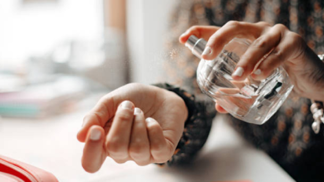 Envases de perfumes y cremas cosméticas sobre un mostrador con etiquetas detalladas de ingredientes.
