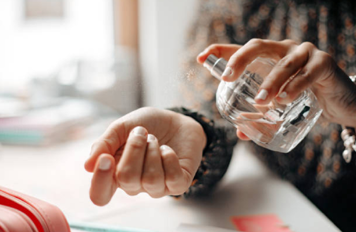 Envases de perfumes y cremas cosméticas sobre un mostrador con etiquetas detalladas de ingredientes.