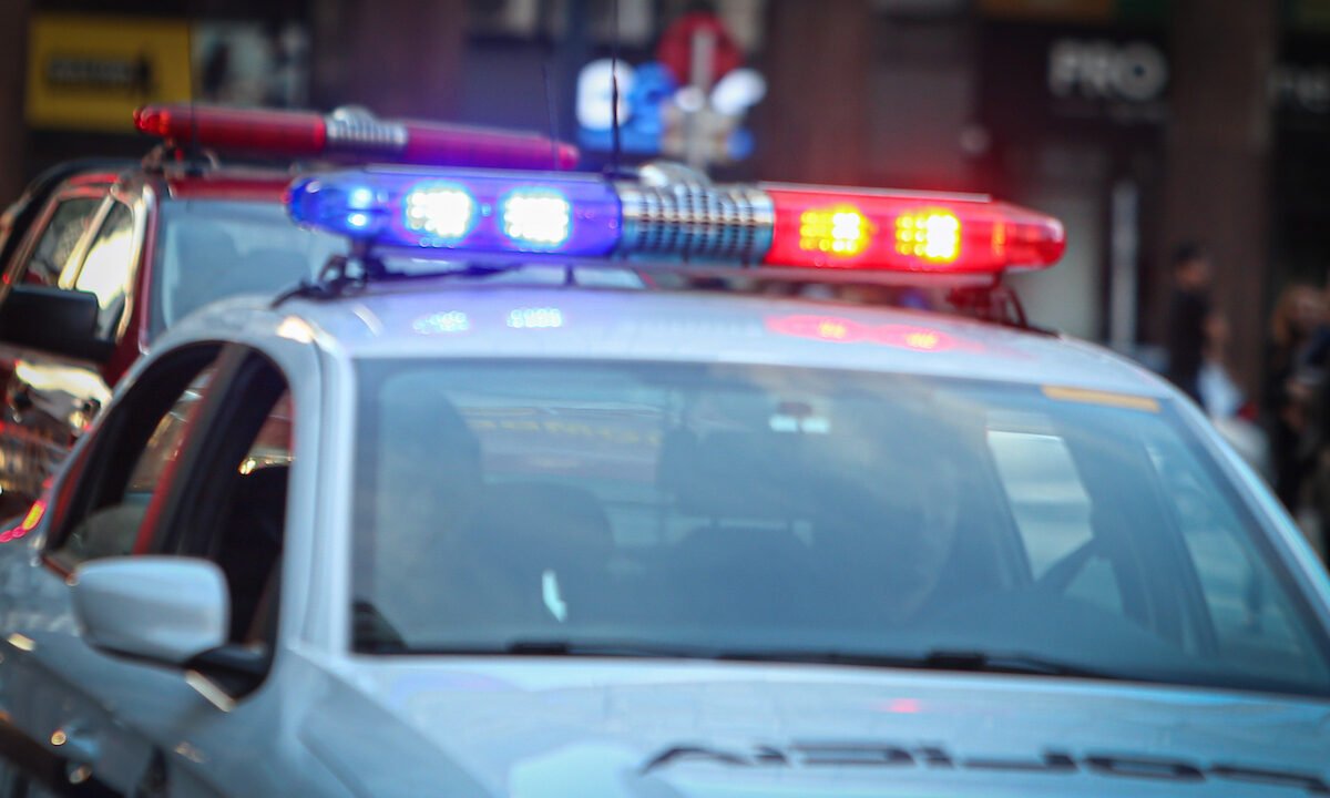 Patrullero policial con luces de emergencia encendidas durante la noche.