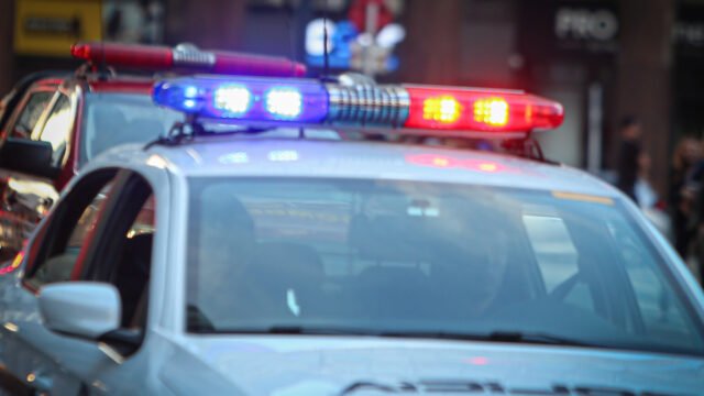 Patrullero policial con luces de emergencia encendidas durante la noche.