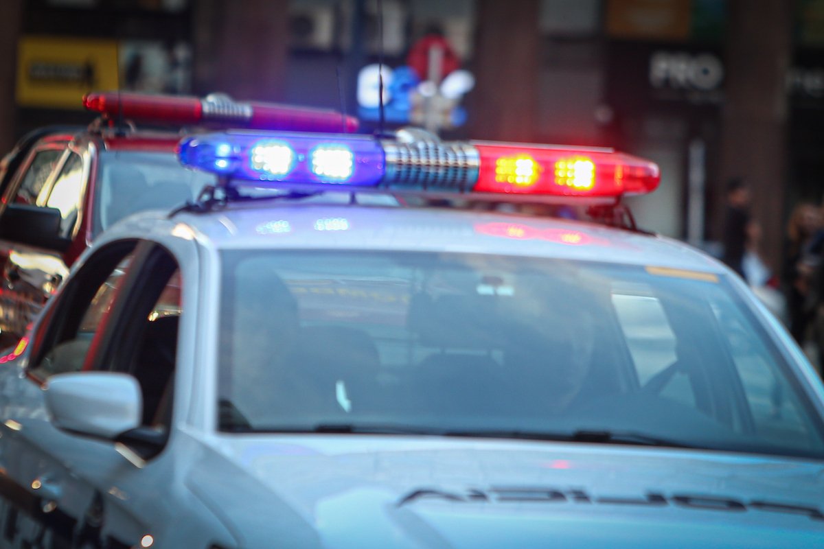 Patrullero policial con luces de emergencia encendidas durante la noche.